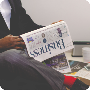 
	Business man sitting in a velor chair while reading the paper Business elegante
